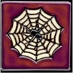 a spider web on a red and white square tile with black border around the center