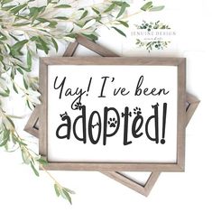 a sign that says yay i've been adopted on it next to some leaves