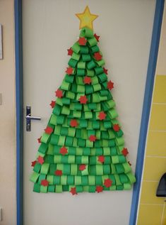 a christmas tree made out of green origami blocks on a door frame with a star