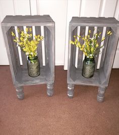 two gray wooden crates with yellow flowers in them sitting on the floor next to each other