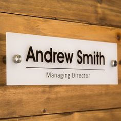 a sign that is on the side of a wooden wall saying, andrew smith managing director