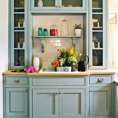 a kitchen filled with lots of green cabinets