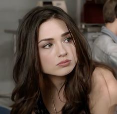 a woman with long brown hair sitting next to a man