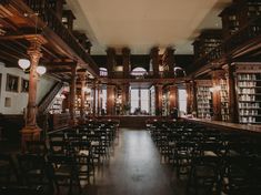 an empty library filled with lots of wooden bookshelves next to tables and chairs