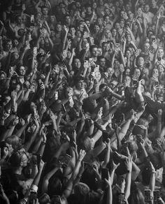 a large crowd of people standing around each other