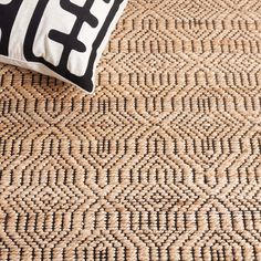 a black and white pillow sitting on top of a rug