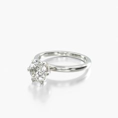 a white gold ring with a single diamond in the center, on a white background