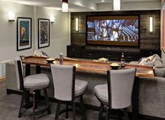 a large dining room table with chairs and a flat screen tv mounted to the wall