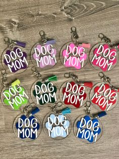 dog mom keychains with different colors and designs are shown on a wooden surface