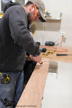 a man is working on a piece of wood