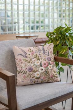 a chair with a pillow on it next to a potted plant