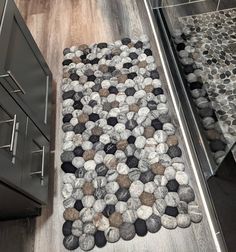 a rug made out of rocks is on the floor next to a cabinet and drawers