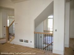 an empty living room with stairs leading up to the second floor and another door on the other side