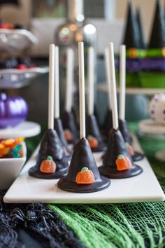 halloween candy cones with candies on them are sitting on a white plate in front of other desserts