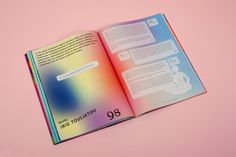 an open book on pink background with blurry image in the middle and rainbow hues