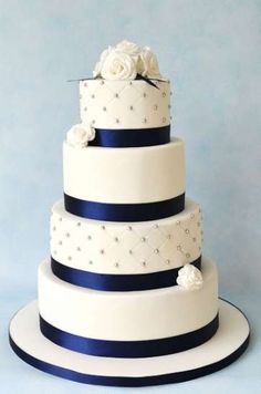 a three tiered white and blue wedding cake