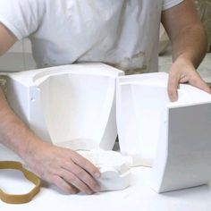 a man is working on an object with scissors and tape around it's edges