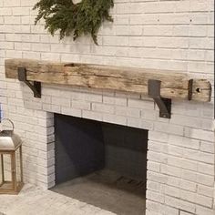 a white brick fireplace with a wreath on the mantel above it and a lantern