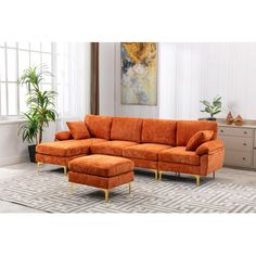 an orange couch and ottoman in a living room