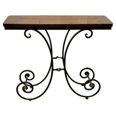 an iron and wood table with scroll designs