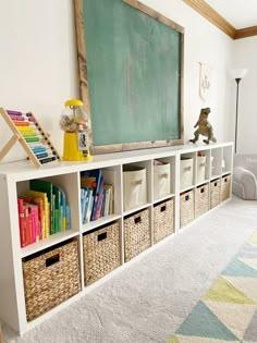 a chalkboard and bookshelf with baskets in front of it