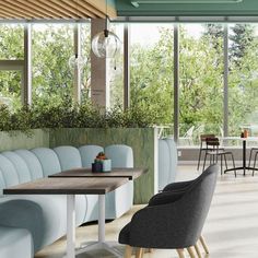 an empty restaurant with blue chairs and tables in front of large windows that look out onto the trees