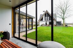 a house with large glass windows overlooking the yard