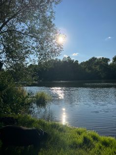 the sun shines brightly in the sky over a lake