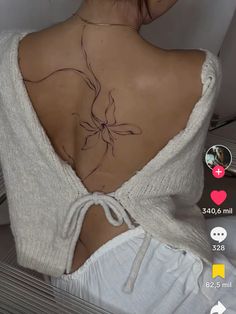 the back of a woman's body with tattoos on it