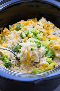 a close up of a spoon in a crock pot with broccoli and cheese