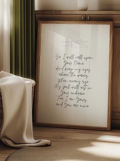 a framed poem is sitting on the floor next to a chair