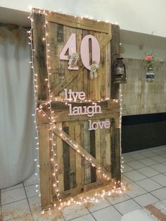 a wooden door decorated with string lights that says live laugh love