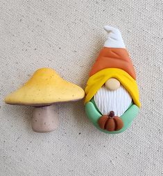 a mushroom with a gnome's face on it next to a small mushroom figurine