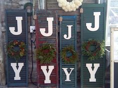 three wooden shutters with wreaths on them and the letters july, yy