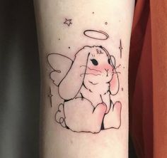 a small tattoo of an angel rabbit on the right arm and leg, with stars in the background