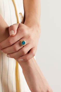 a woman's hand with a ring on her left wrist, wearing a striped dress