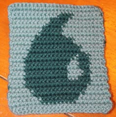 a crocheted square with a green circle on it