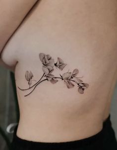 a close up of a woman's stomach with tattoos on it and flowers growing out of the side