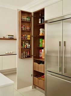 an open pantry door in the middle of a kitchen