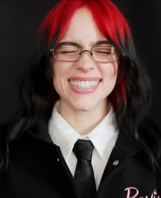 a woman with red hair and glasses smiling