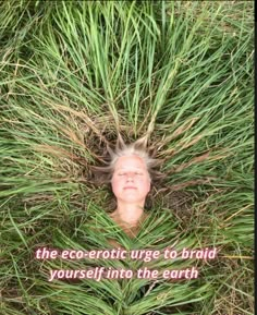 a woman is laying in the grass with her eyes closed and head hidden by tall grass