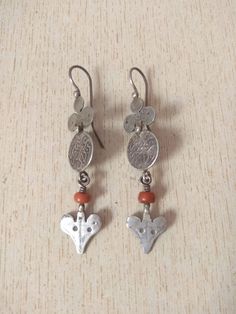 This is a beautiful old silver berber earrings from morocco with old coral beads.  These earrings consist of silver heart and coin silver, one on top of the other, with Old coral & heart hanging from them.  Length : 7,5 cm (2,9 inches)  Width : 1,6 cm (0,6 inches)  Weight : 10,4 g Berber Earrings, Berber Jewelry, Moroccan Jewelry, Coral Beads, Heart Earrings, Silver Heart, Morocco, Favorite Jewelry, Antique Silver