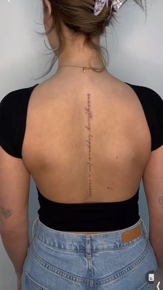 the back of a woman's upper body with writing on her left shoulder and lower back