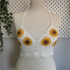 a mannequin wearing a white top with yellow sunflowers on the front