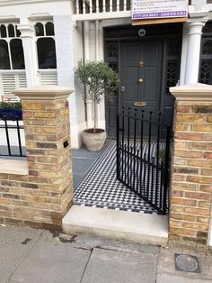 a black and white checkered tile floor in front of a building with a door