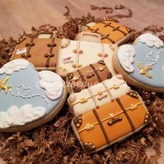 four decorated cookies in the shape of suitcases