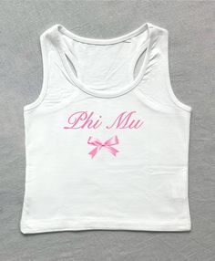 a white tank top with pink lettering and a bow on the front that says phi mia