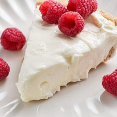 a piece of pie with white frosting and raspberries on top