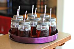 six mason jars filled with liquid sitting on top of a table