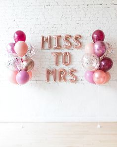 some balloons are hanging on the wall and there is a sign that says miss to mrs